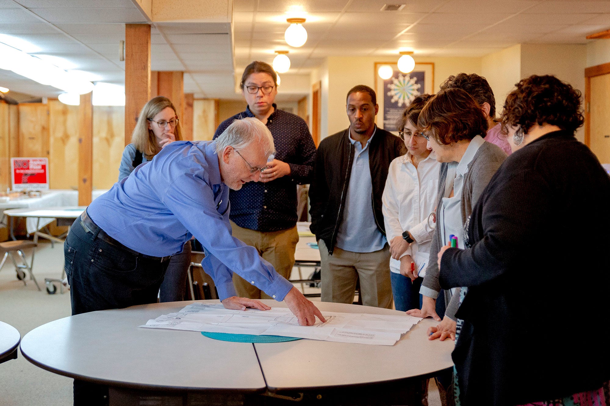 Earthjustice attorneys and community partners look at the site plan for the Ajax asphalt plant sited in the Dort-Carpenter Industrial Park during a meeting at St. Francis Prayer Center on May 10, 2022, in Flint, Michigan.