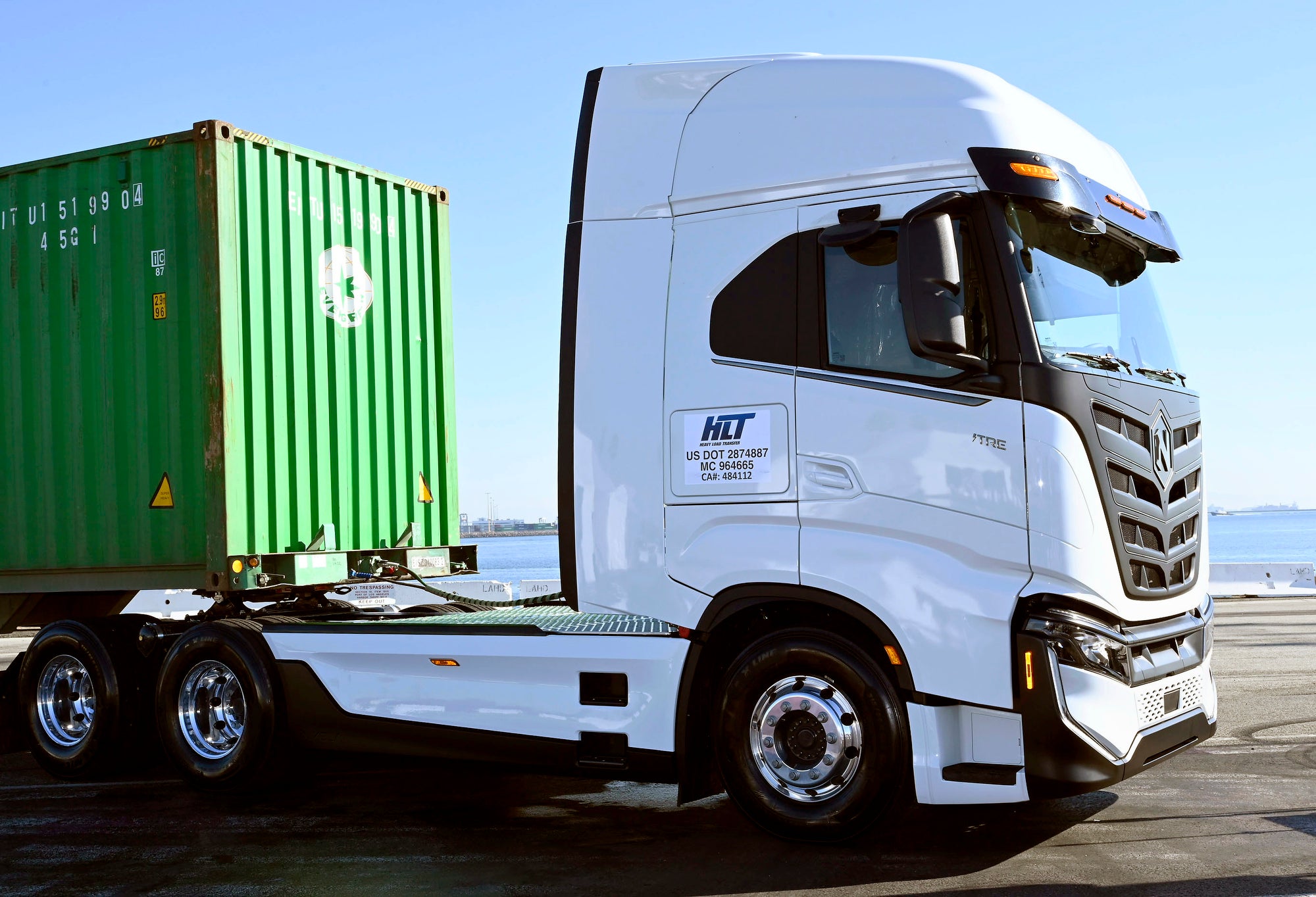 A white semi truck with a green container