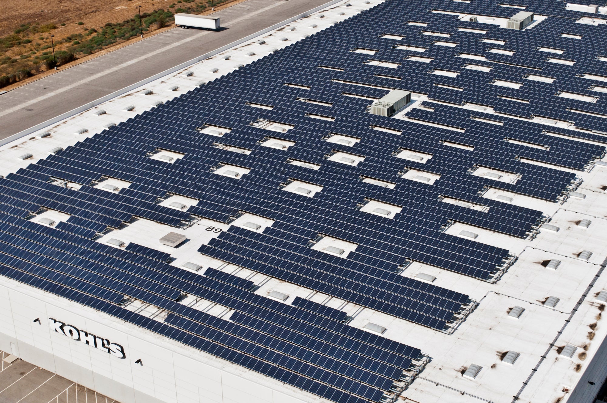A large white warehouse covered with dark solar panels