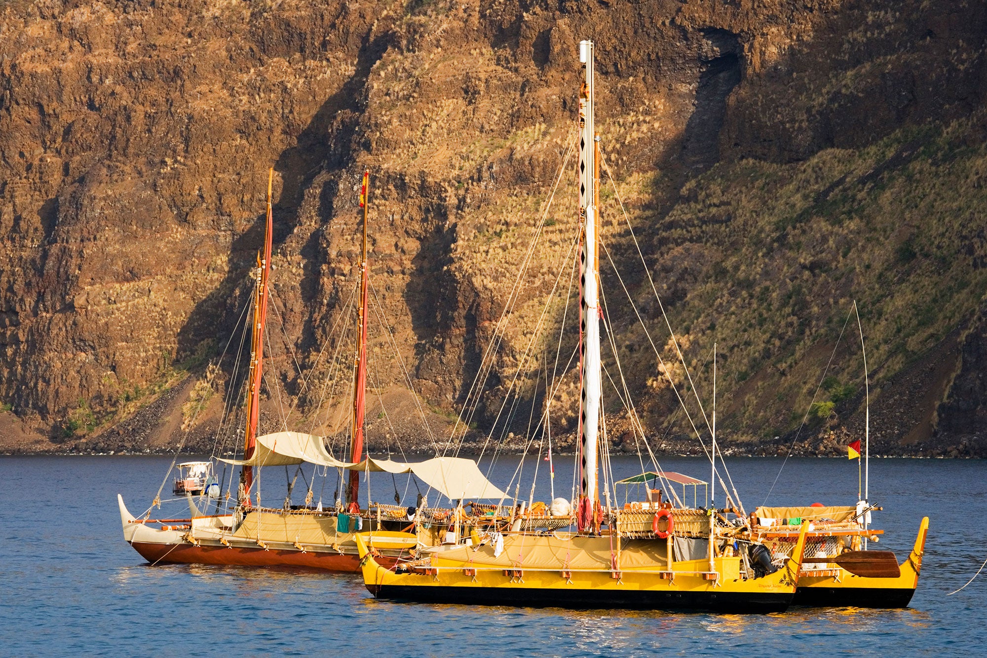 Hawaiian voyaging canoes Hokulea (left) and Alingano Maisu moored in Kealakekua Bay for repairs on a 2007 trip to gift the Alingano Maisu to master navigator Mau Piailug of Satawal for his thirty years of reintroducing noninstrument navigation to Hawaiians.