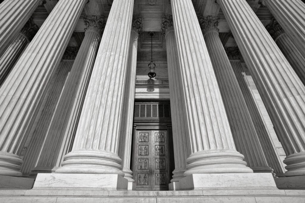 An upward view of the U.S. Supreme Court building near the top of the front steps.