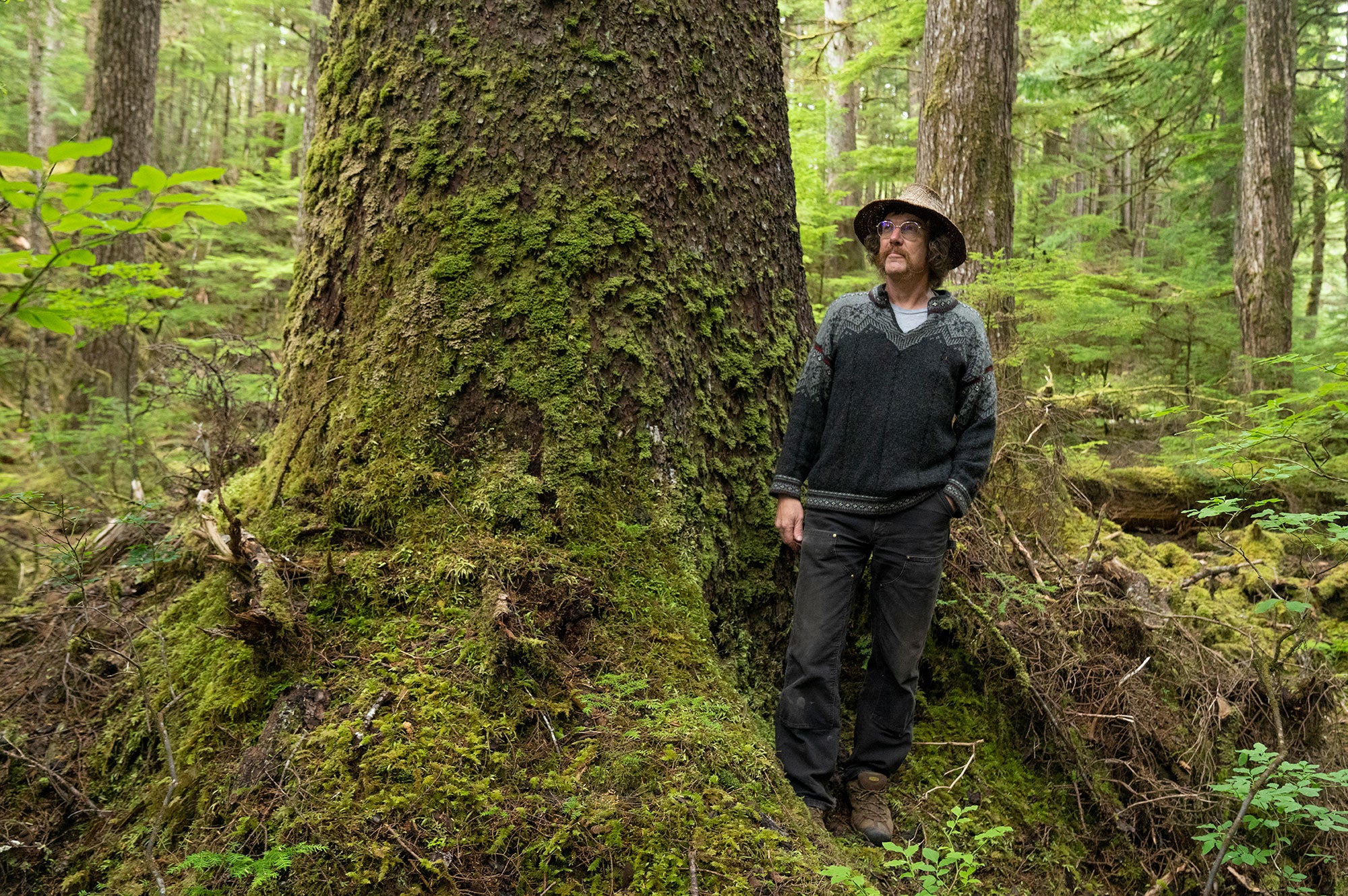 Stormy Hamar, a Haida artist and carver and an Organized Village of Kasaan tribal council member, stands among old-growth trees near Kasaan, Alaska.